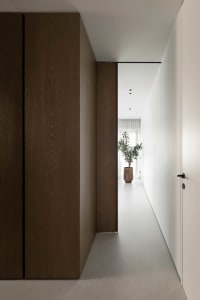 Modern interior design featuring a spacious hallway with concrete flooring.