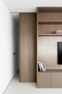 Modern interior with a wooden bookshelf featuring clean lines and a minimalist design.