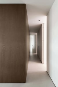 A minimalist corridor featuring concrete and wooden walls.