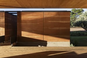 Modern wooden exterior house wall panels with natural light casting shadows on a porch