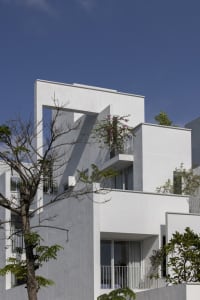 Modern residential building with white and grey concrete exterior.