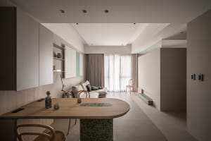 Modern living room with minimalist furniture, neutral color palette, and concrete flooring and furnishings.