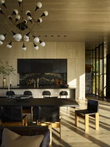 Contemporary residential kitchen dining area featuring wooden paneling and a black marble kitchen island.