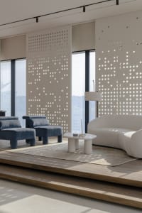 Modern living room featuring white curved sofa, blue upholstered chairs, wooden steps, and large windows with geometric wall 
