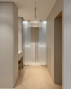 A modern interior design featuring a white closet with frosted glass doors.