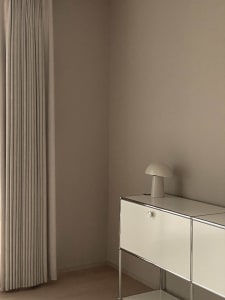 Modern minimalist dresser with white lighting and metallic steel frame.