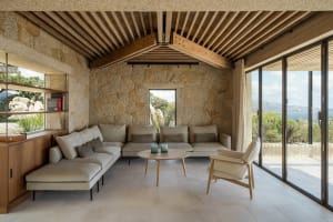 A minimalist residential interior featuring stone, wood, and glass materials.