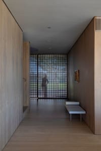 A modern hallway with wood walls and a glass panel at the end.