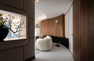 A modern living room featuring a curved wall, white sofa, and floor lamp.