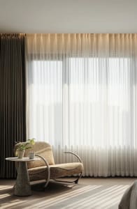 A modern living room featuring white draperies and soft lighting.