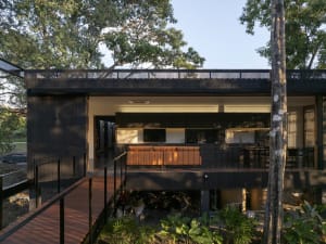 Modern residential architecture with a wooden exterior and an open, airy interior.