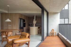 A modern residential kitchen featuring wood and concrete materials.