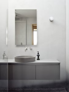 Modern bathroom with concrete sink, mirror, and cabinet.