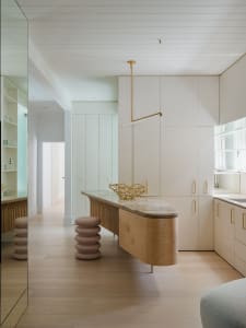A modern minimalist kitchen featuring marble countertops and wooden elements