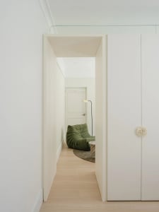 A minimalist living room with wood flooring and a green lounge chair.