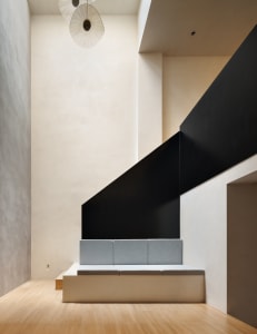 A minimalist living room with exposed concrete walls and a floating bench seat.