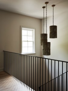 A modern staircase features chain-hanging metal fixtures.