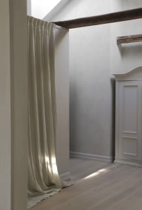 A minimalist interior space with light-colored fabric and wooden elements