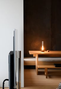 A photograph showcasing a minimalist residential interior featuring industrial-style timber and metallic elements.