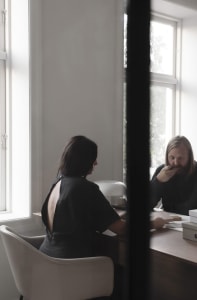 Two individuals engaged in a meeting within a modern office setting.