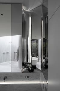 A modern minimalist bathroom with marble tiles and fixtures.