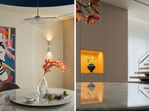 A modern dining room with a marble table and a round, white pendant light hanging above.