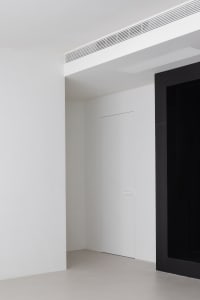 A minimalist interior with white walls and a concrete floor.