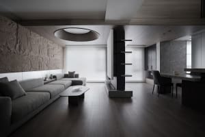 A modern living room with a stone accent wall, wooden accents, and glass elements.