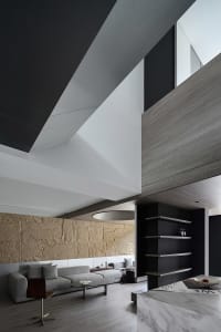 Minimalist modern living room featuring wood tiles and a concrete vault ceiling.