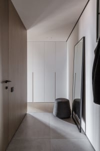 Modern minimalist closet with concrete flooring and white cabinetry.