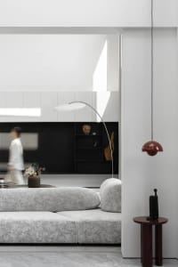 A modern white living room with a textured sofa, minimalist decor, and sleek furniture.