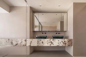 Modern bathroom with glass countertops and white walls.