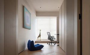 A modern home office featuring a glass window with a stylish interior design.