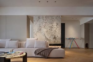 A modern minimalist living room featuring marble and wooden elements.