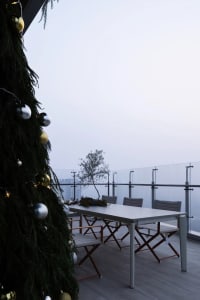 A well-decorated Christmas tree with a table setting in the background.