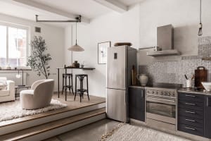 A minimalist kitchen featuring concrete and stainless steel elements.