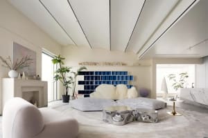 Minimalist residential room with white furniture and a blue accent wall.