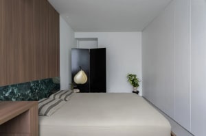 Modern bedroom interior with concrete walls and minimalist design elements.
