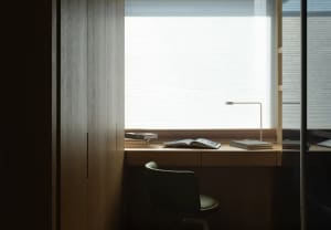 Minimalist office with a window view, wooden desk, and simple design elements.