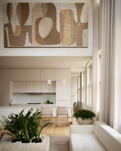 Modern kitchen and living room featuring neutral-toned materials and an open-concept layout.