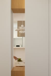 A minimalist kitchen with white cabinets and a countertop.