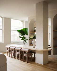 Modern minimalist living room with concrete elements and wooden flooring.