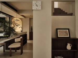 Modern residential kitchen featuring concrete walls, wooden furniture, and leather accents