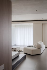 A modern interior design featuring neutral colors, including a plush white sofa and minimalist furniture.