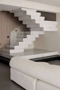 Modern interior design featuring a contemporary marble staircase in a living room setting.