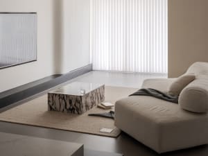 A minimalist residential interior featuring a marble floor and minimalist furniture.