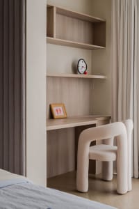 A modern wooden bedroom with a comfortable chair, shelves, and a clock.