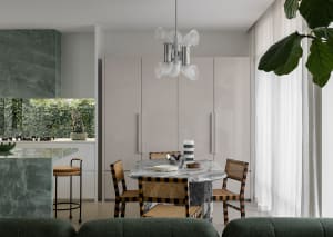 A modern kitchen featuring a distinctive marble dining table surrounded by woven chairs, situated in a contemporary residenti