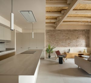 A modern kitchen with minimalist design features concrete countertops and walls.