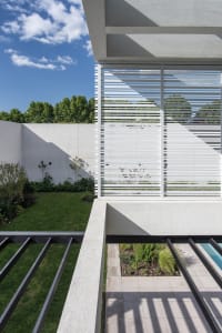 A modern concrete exterior with a lattice structure and greenery.